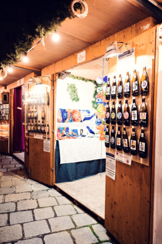 Handicraft vendor at Christkindlmarkt Am Hof selling traditional Austrian items.