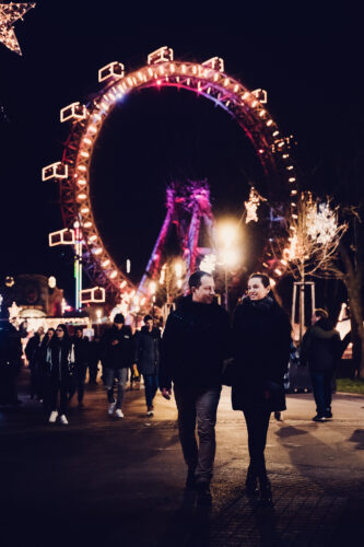 Adriana and Mario walking through Wintermarkt at Prater amusement park Vienna.