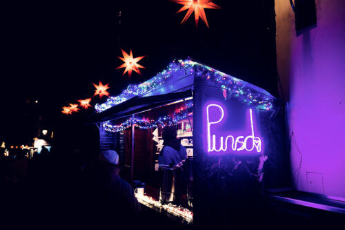 Hot beverage stand at Christmas market on Spittelberg historic streets.