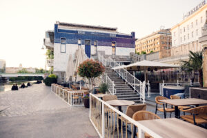 Donaukanal waterfront with outdoor seating areas.
