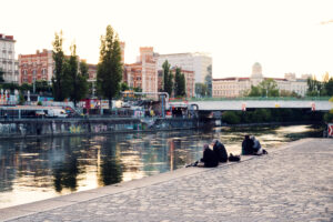 Donaukanal at sunset with Vienna skyline reflection.