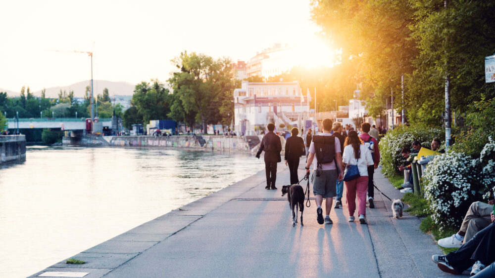 People relaxing along Donaukanal promenade.