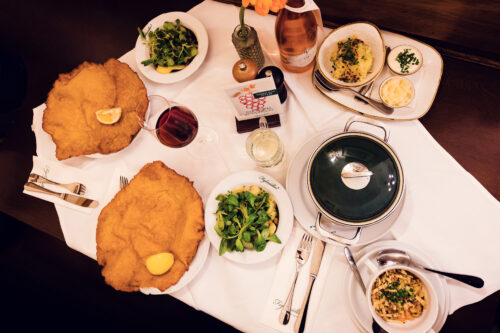 Plate-sized Wiener Schnitzel and Tafelspitz specialty at Figlmüller restaurant with traditional side dishes.