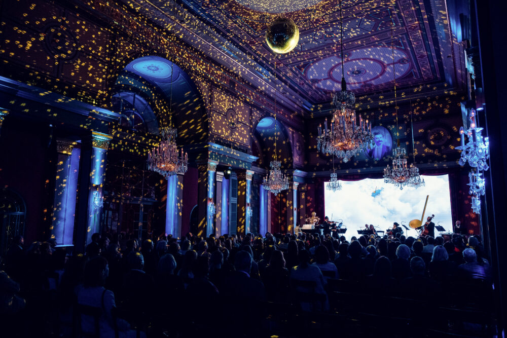 Sala Strauss illuminata di blu con effetti di luce dorata durante una serata di concerto.
