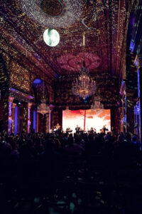 Full concert hall view with colorful light show projections in the Strauss Hall.