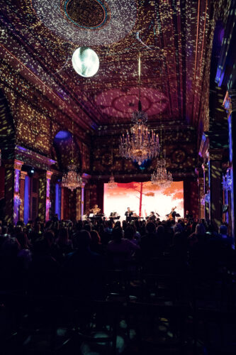 Full concert hall view with colorful light show projections in the Strauss Hall.
