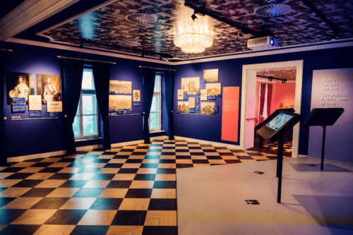 Interactive museum display with touchscreen and historical panels at House of Strauss.