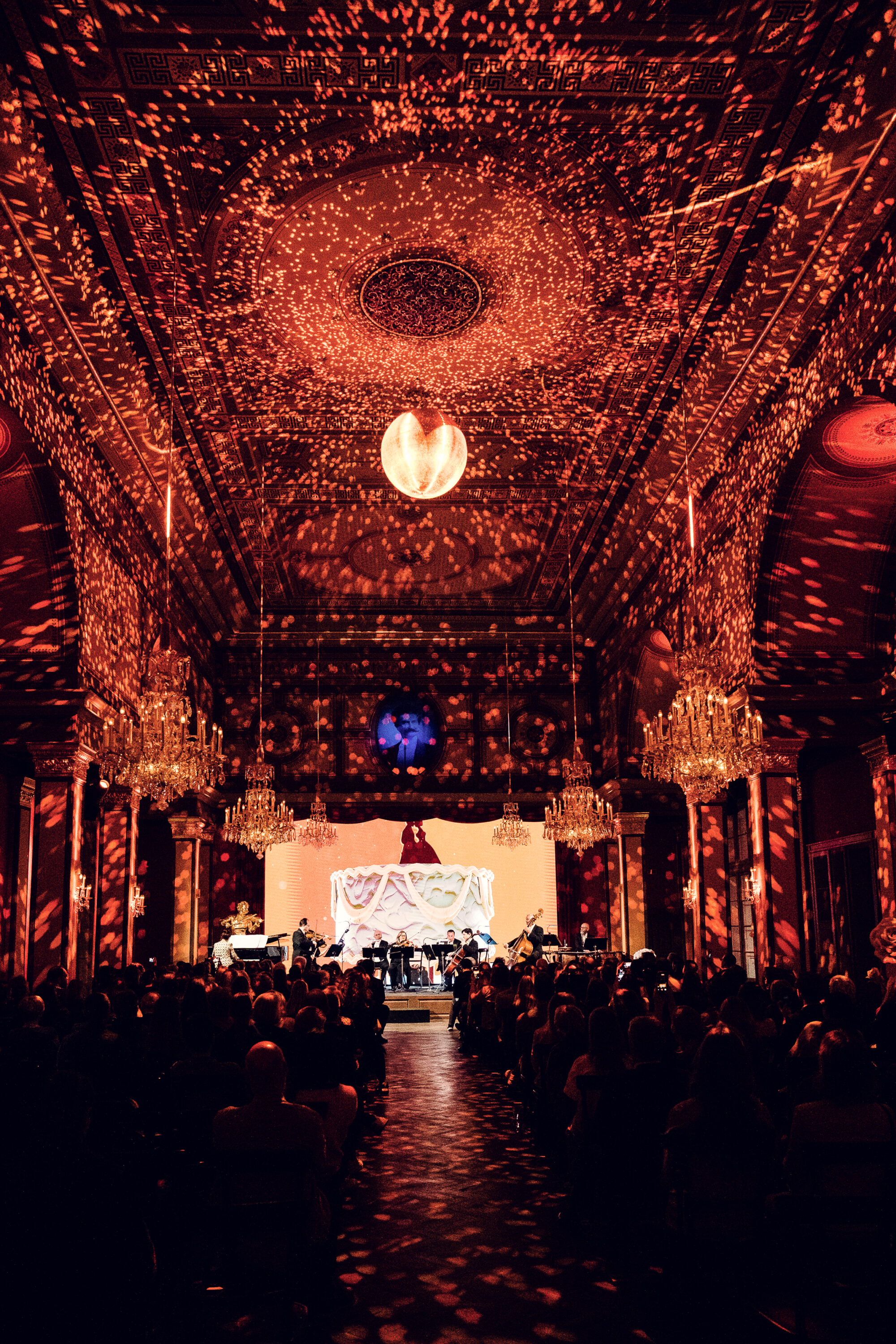 Strauss Hall concert with warm light projections across the vaulted ceiling.