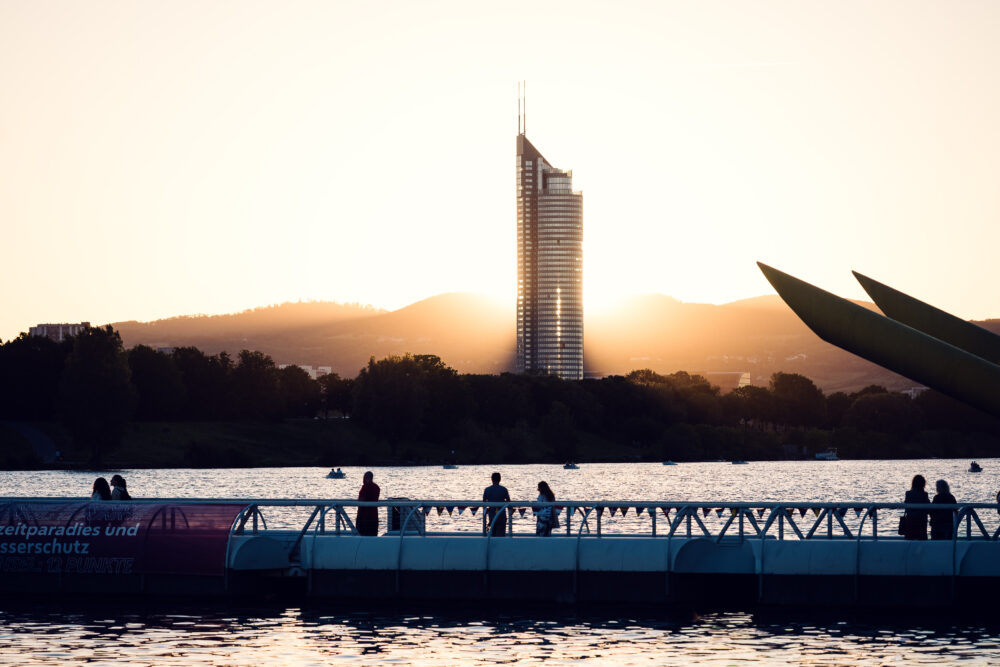 Visitors on the floating bridge at sunset with the Millennium Tower beyond Copa Beach.