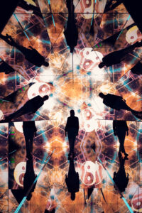 Adriana standing in the pyramid room with warm orange kaleidoscopic projections and circular symbols.