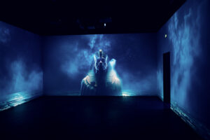 Large sphinx projection in blue tones filling the walls of the 360-degree show room.