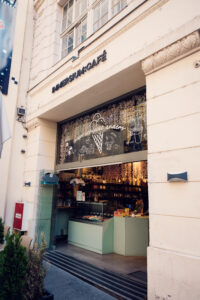Shopfront of the Immersium Cafe with a mint-green counter and decorated window display.