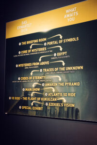 Exhibition overview board listing all 14 stations of the World of Mysteries experience.
