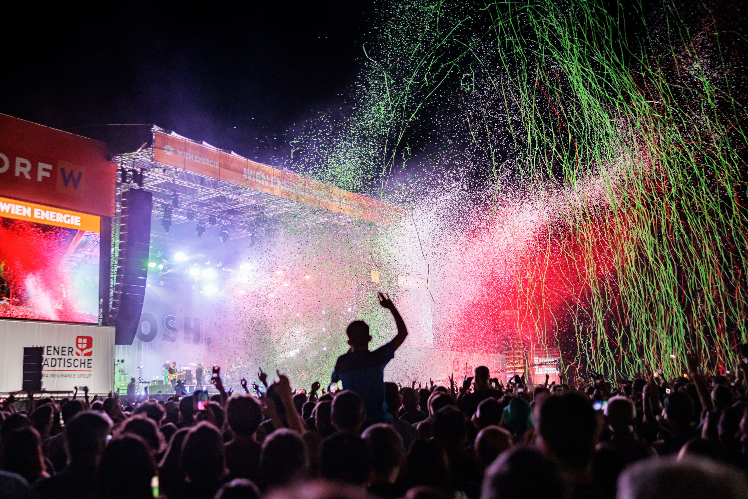 Crowd at the Donauinselfest main stage at night with green and red streamers shooting over the audience © Donauinselfest / Alexander Müller