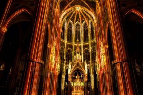 High altar of the Votivkirche glowing in golden light during Light of Creation.