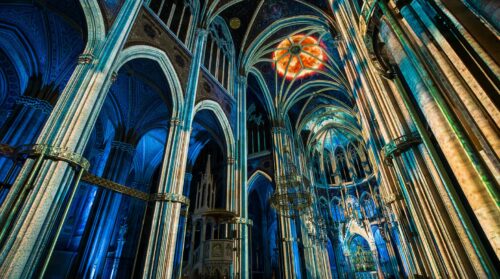 Glowing sun projected on the starry vaulted ceiling of the Votivkirche during Light of Creation.